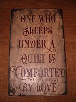 One who sleeps under a quilt sign